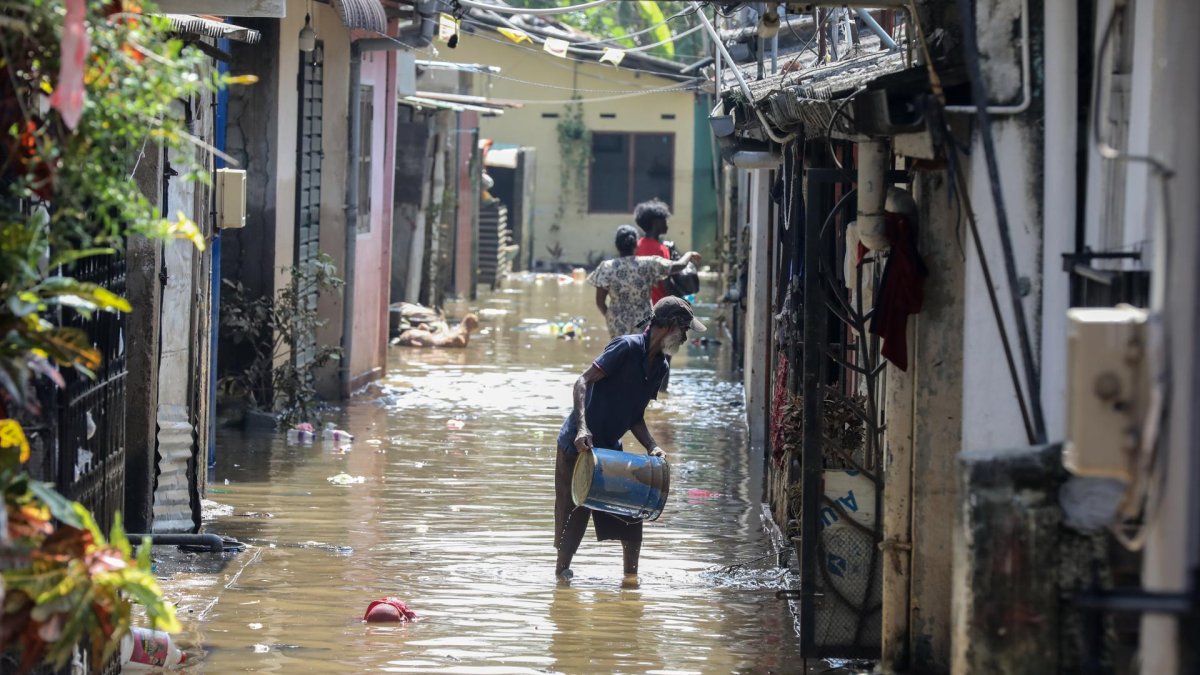 Personas afectadas por las inundaciones en Sri Lanka limpian su casa cubierta de barro y agua, el 3 de diciembre de 2025.
