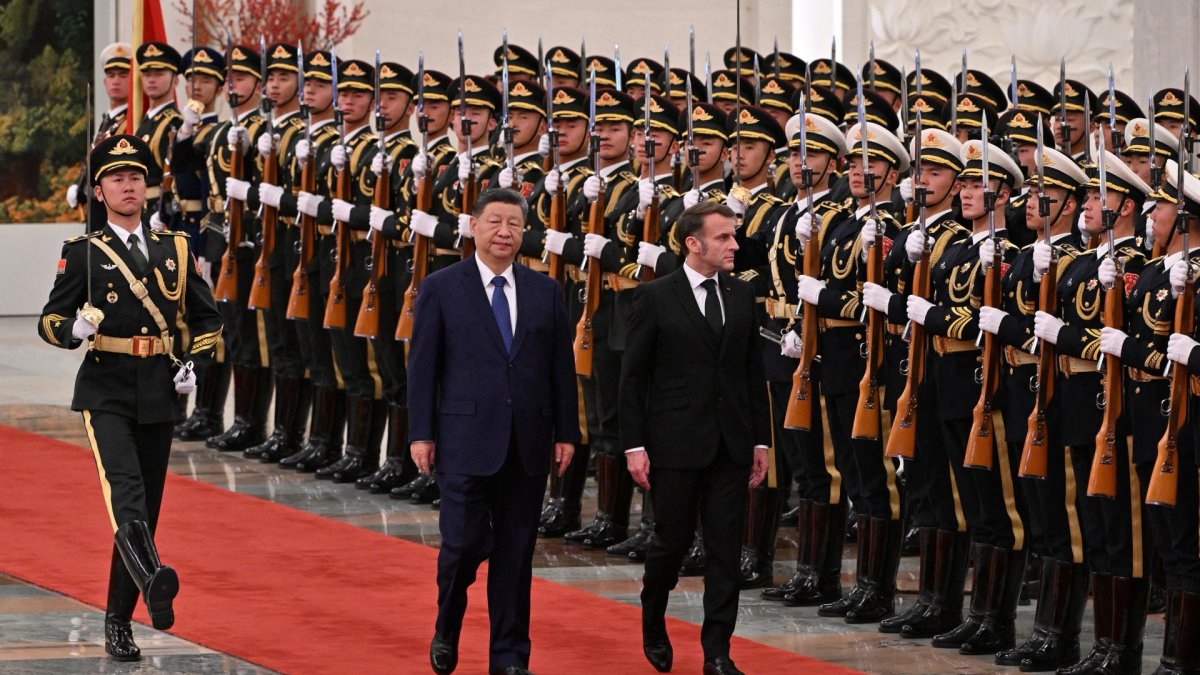 El presidente Emmanuel Macron y el presidente Xi Jinping, pasan revista a la guardia de honor durante una visita de Estado al Gran Salón del Pueblo en Pekín, el 4 de diciembre de 2025.