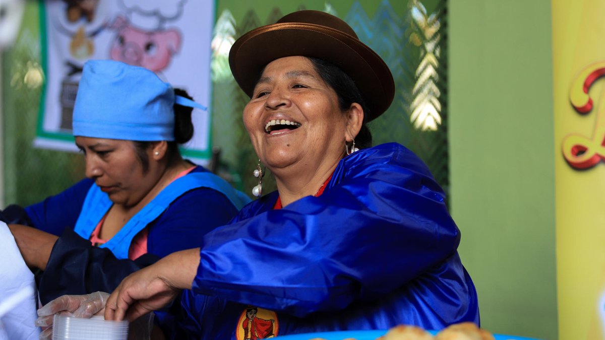 Una cocinera sirve platos tradicionales durante el lanzamiento del circuito SUMAQ, en La Paz (Bolivia).