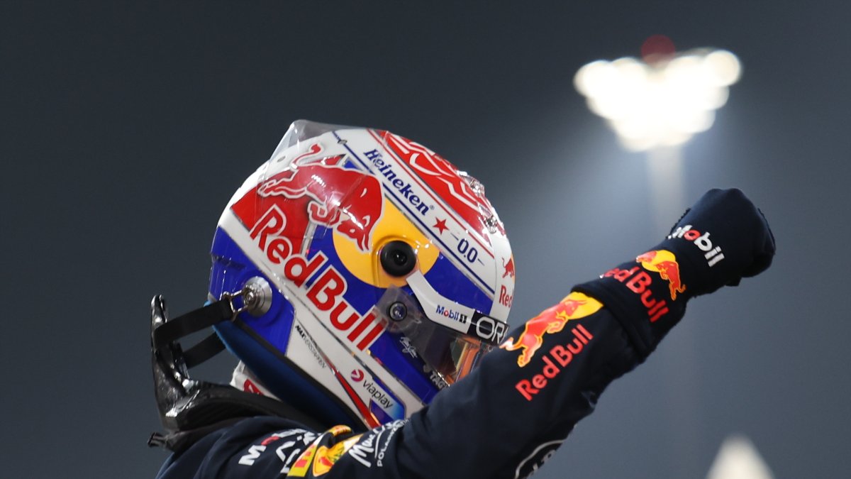 EL piloto de Red Bull Racing Max Verstappen levanta la mano en señal de victoria.