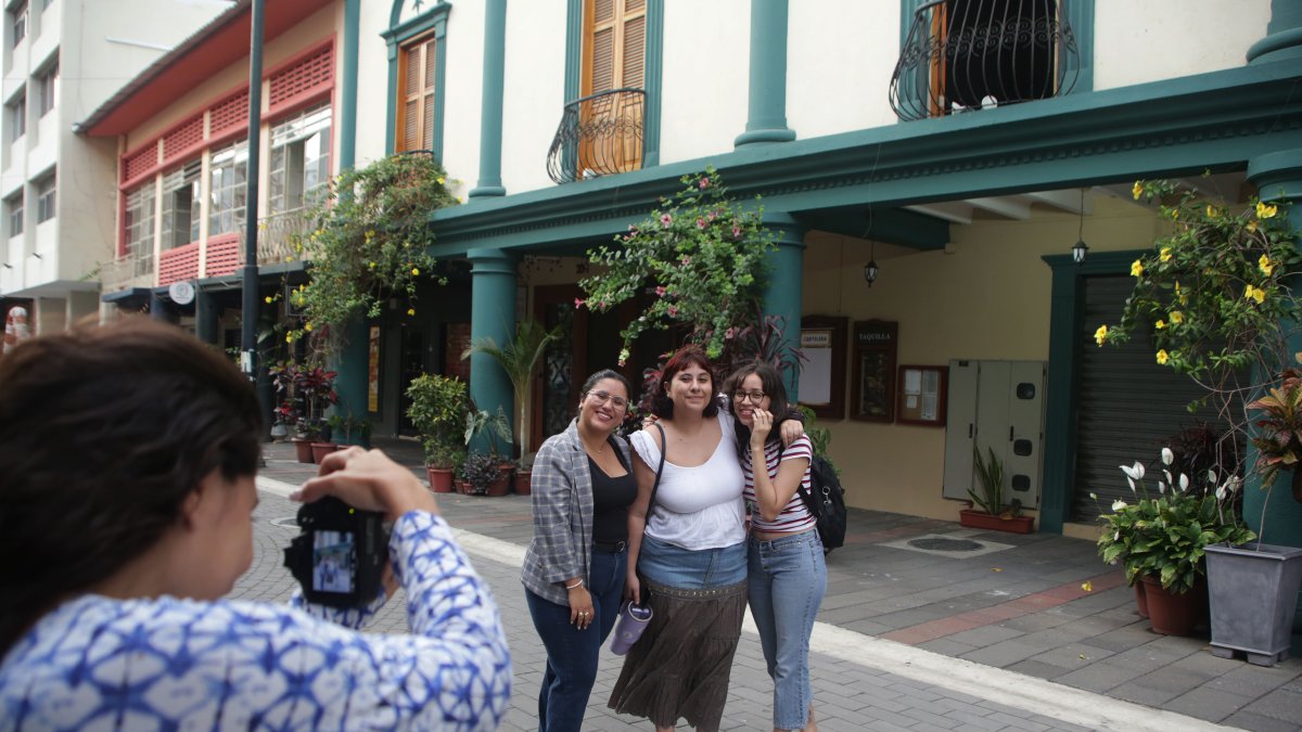 Las personas inmortalizan a la ciudad junto a sus recuerdos en una fotografía al aire libre.