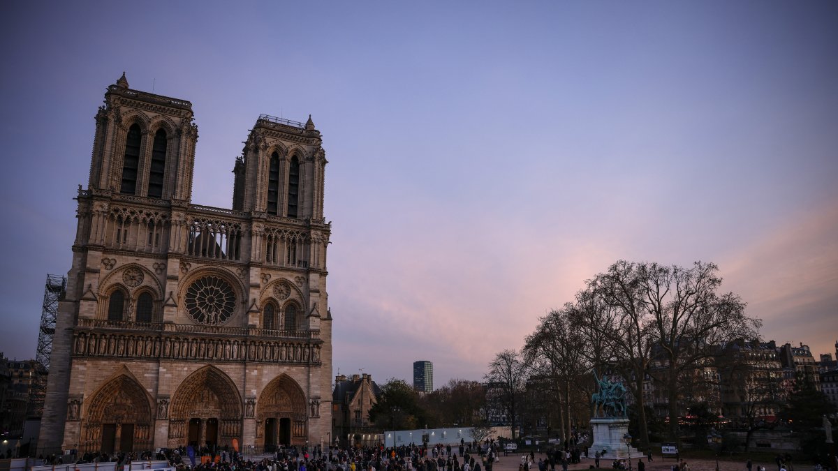 Monumento. Visitantes de diferentes partes del mundo se reúnen fuera de la Catedral de Notre Dame, un año después de la reapertura en París.