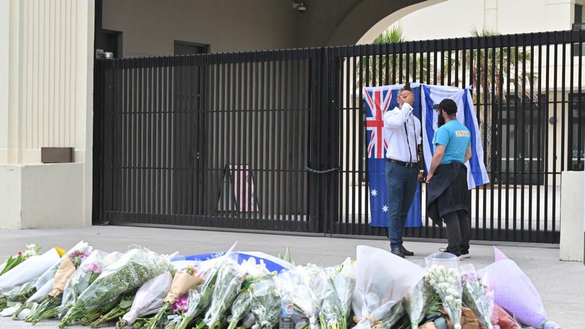 Las banderas de Australia e Israel, junto a decenas de ramos de flores, en recuerdo de las víctimas del atentado en la playa de Bondi, en la ciudad de Sídney.