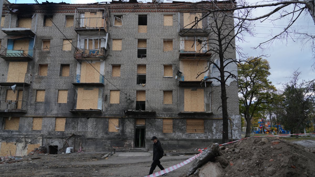 Aislados. Bogdan Levchikov, un adolescente de 15 años, camina junto a un edificio residencial dañado en Balakliya.