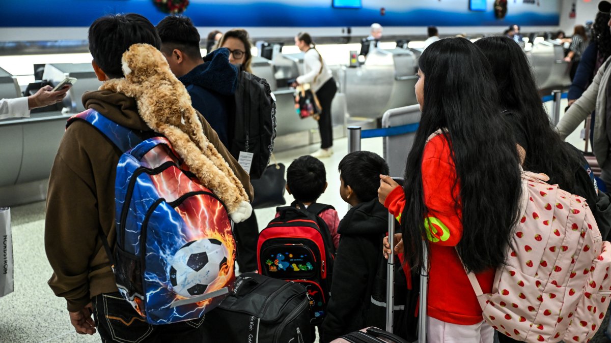 Viaje. Los niños son escoltados en el Aeropuerto Internacional de Miami antes de volar a Guatemala, donde se reunirán con sus padres recientemente deportados.