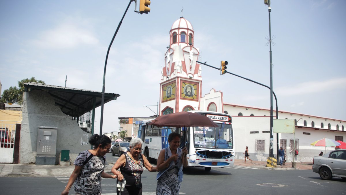 Suroeste. Tres ciudadanas cruzan por la calle A, diagonal a la iglesia del Cristo del Consuelo, templo que pertenece a la parroquia Febres Cordero.