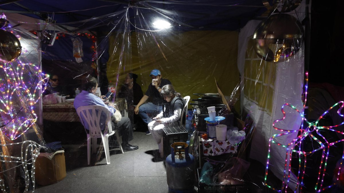 Familias se reúnen en un campamento de personas desalojadas este sábado, en la Ciudad de México (México).