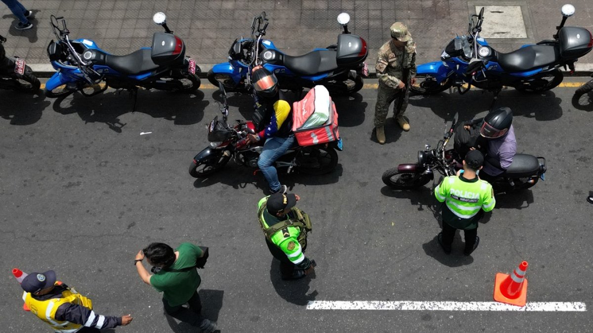 Agentes de policía registran a motociclistas en un puesto de control después de que el gobierno declarara el estado de emergencia en Lima el 22 de octubre de 2025.