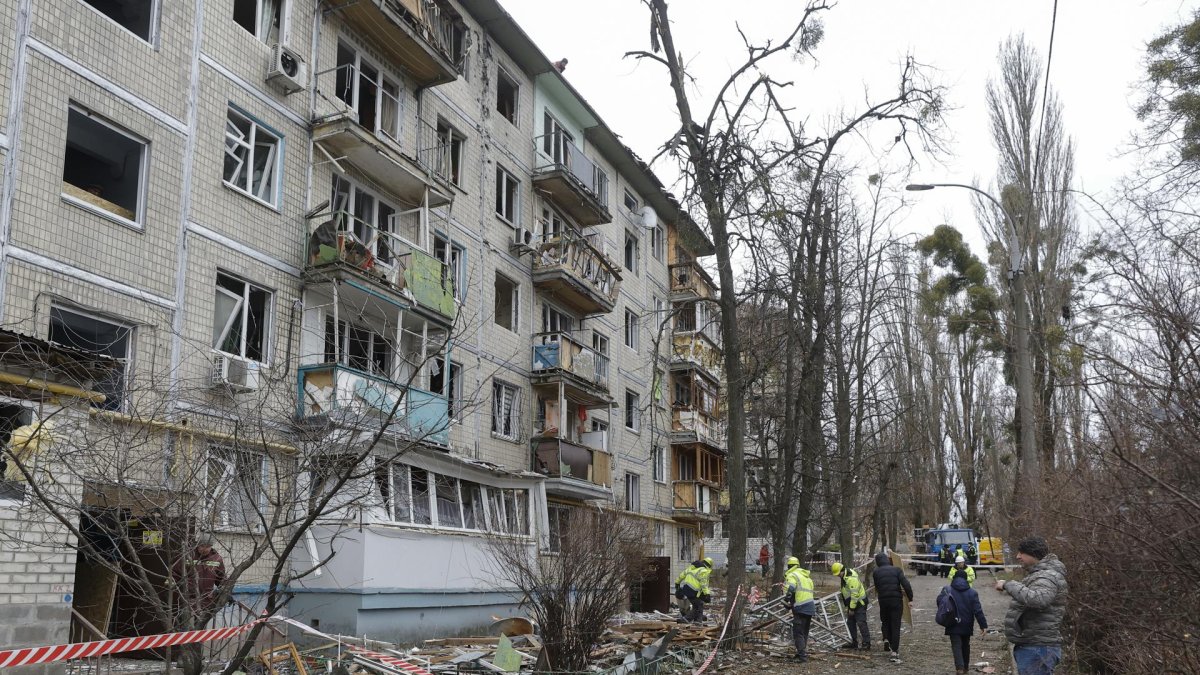 Trabajadores comunitarios ucranianos limpian escombros en el lugar donde un dron ruso atacó un edificio residencial de cinco plantas en Kiev, Ucrania, durante la invasión rusa.