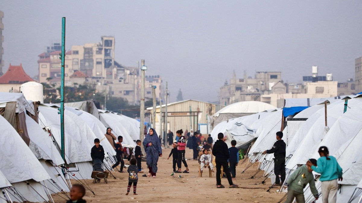 La gente camina entre los refugios en el campamento de Nuseirat para palestinos desplazados en el centro de la Franja de Gaza el 22 de diciembre de 2025.