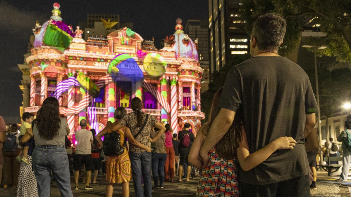 Personas observan la proyección navideña inspirada en el ballet clásico de Chaikovski, El cascanueces, en la fachada del Teatro Municipal de Río de Janeiro (Brasil).