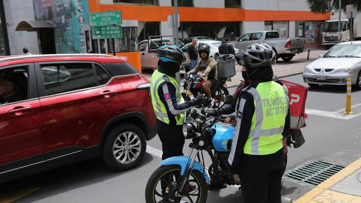 En la av. Diego de Almagro, norte de Quito, un agente civil de tránsito recuerda la normativa a un motociclista.