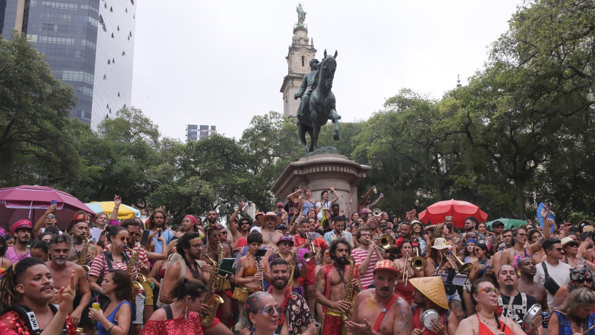 Personas participan en un desfile de una comparsa callejera este domingo, en Río de Janeiro (Brasil).