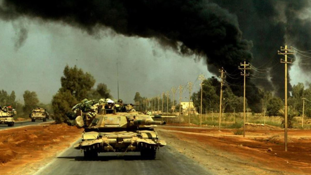 Blindados avanzan entre el humo de un pasado conflicto en Irak.