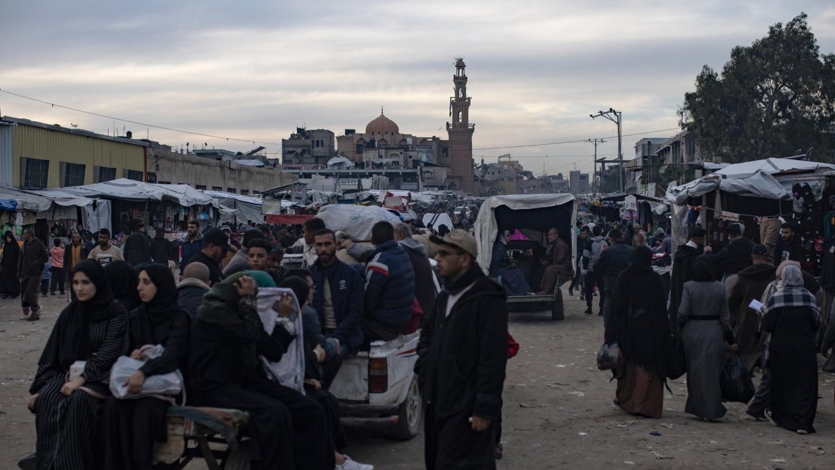 Palestinos desplazados caminan por una de las calles de la ciudad de Khan Younis en la franja de Gaza sur, 04 de enero de 2026, en medio de difíciles condiciones humanitarias.