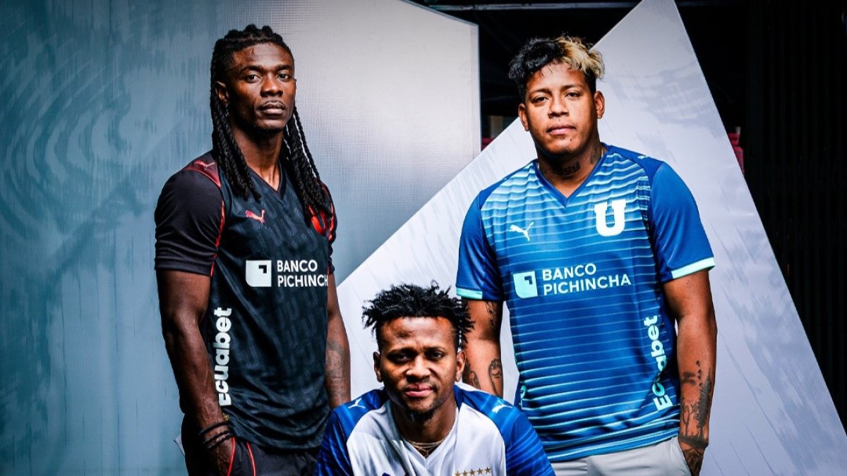 Ricardo Adé (I), Michael Estrada (C) y Richard Mina (D) posan con la nueva indumentaria de Liga de Quito para el 2026.