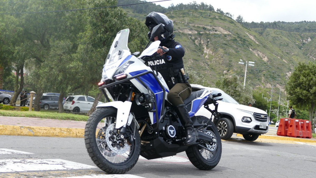 Un agente de la Policía Nacional patrulla en motocicleta una zona montañosa de Ecuador, en labores de vigilancia preventiva.