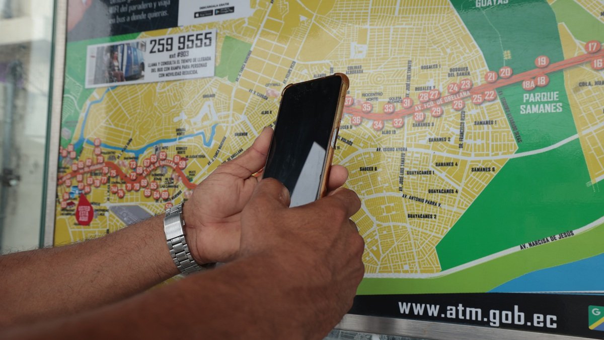 Ciudadanos buscan revisar en sus celulares las rutas de buses urbanos que transitan por el norte de Guayaquil.
