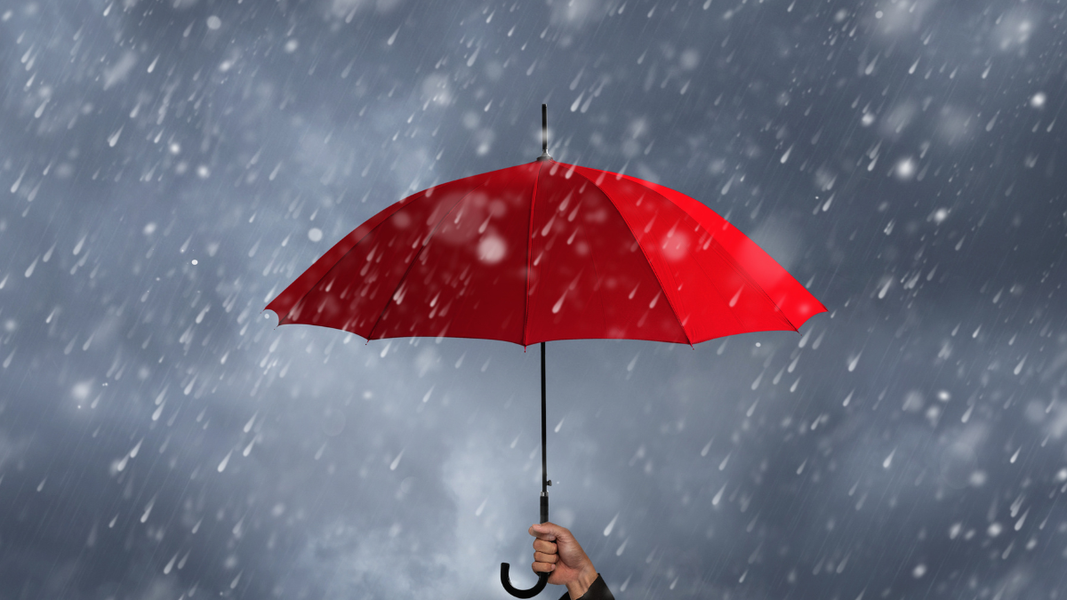 Referencial. Una persona se resguarda bajo un paraguas durante las lluvias en Ecuador, en medio de alertas por tormentas emitidas por Inamhi.