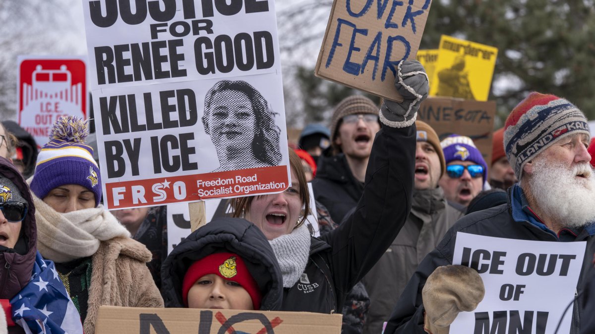 Personas sostienen carteles durante una manifestación en rechazo a los operativos del Servicio de Inmigración y Control de Aduanas (ICE) en Mineápolis (Estados Unidos).