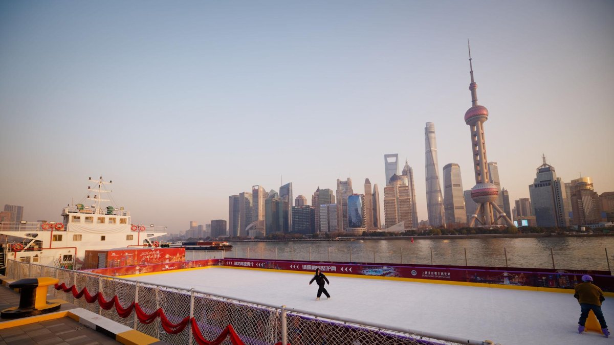 La gente patina en un barco de carga convertido en pista de patinaje sobre hielo en el río Huangpu en Shanghai, China, el 13 de enero de 2026.