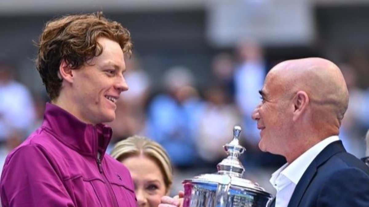 Jannik Sinner (I) recibiendo un premio de la leyenda, Andre Agassi (D).