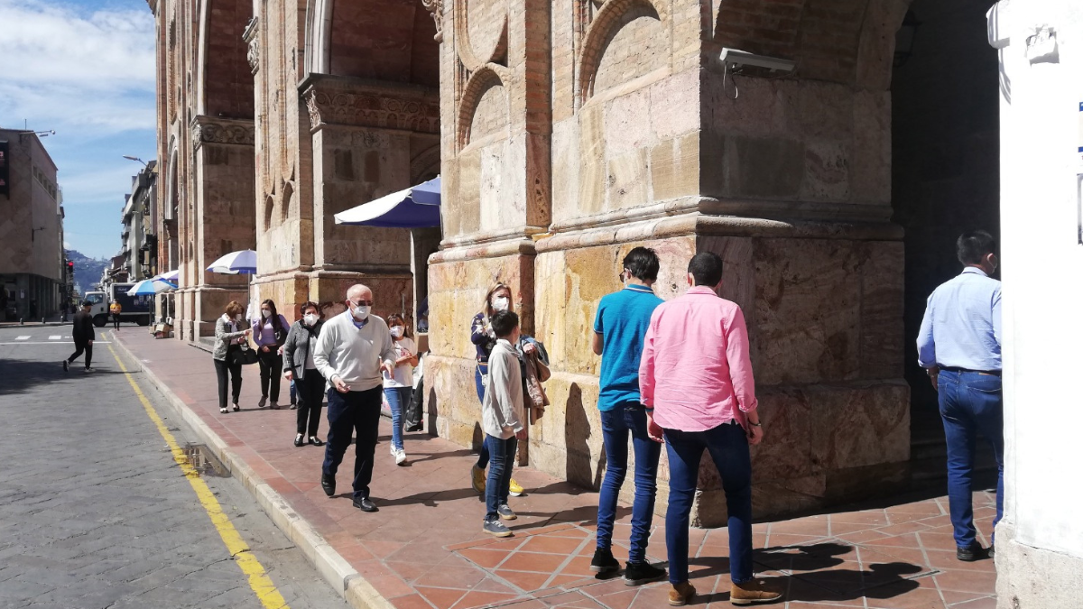 Turistas recorren el centro histórico de Cuenca, frente a una de sus iglesias patrimoniales.