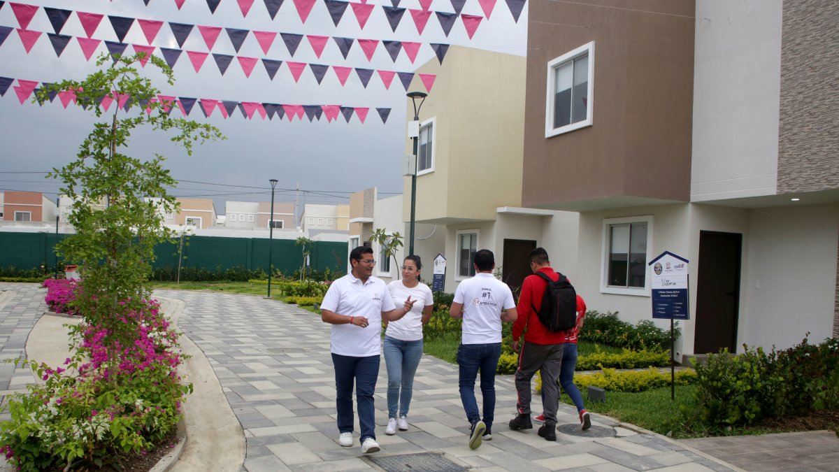 Un grupo de personas visitan y revisan los inmuebles que se venden en la vía a la costa, donde se ofrecen casas de interés social.