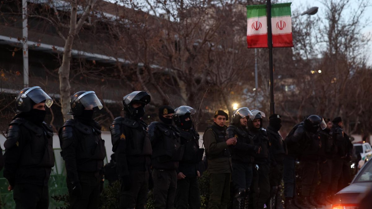 La policía antidisturbios iraní vigila mientras los estudiantes protestan frente a la embajada británica en Teherán, Irán, 14 de enero de 2026.