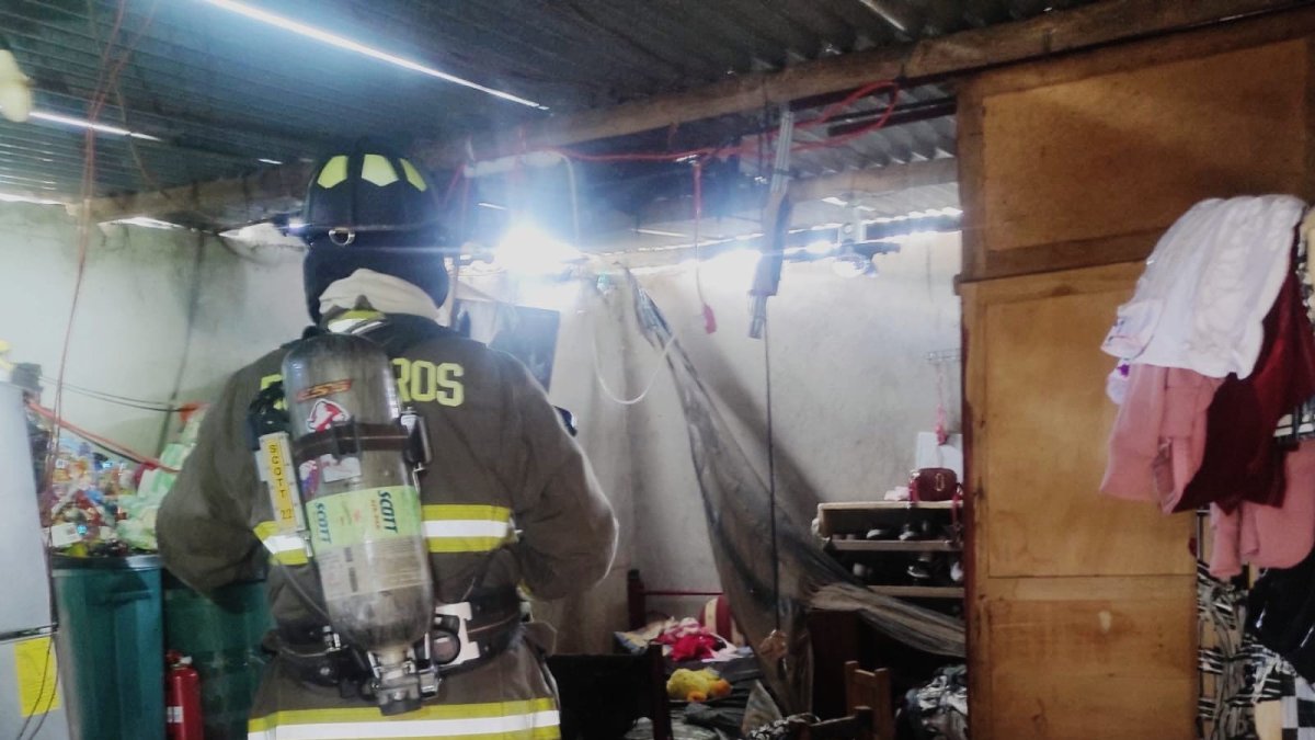 Personal del Cuerpo de Bomberos de Mejía atiende una emergencia por deflagración de gas GLP en una vivienda del sector Aloasí.