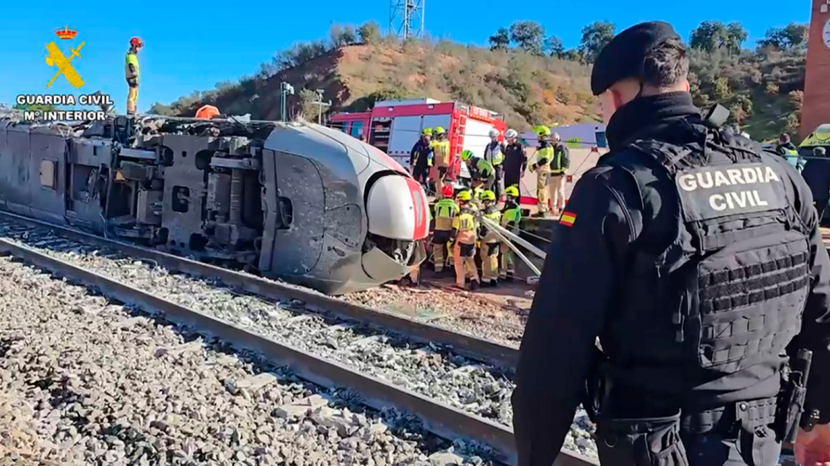 Guardia Civil y bomberos trabajan entre los restos del tren tras el choque en Córdoba.