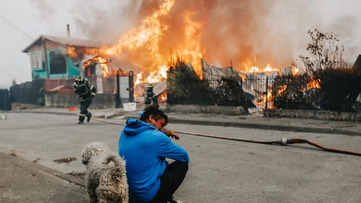 Un hombre observa casas afectadas por incendios forestales este domingo, en Penco (Chile).