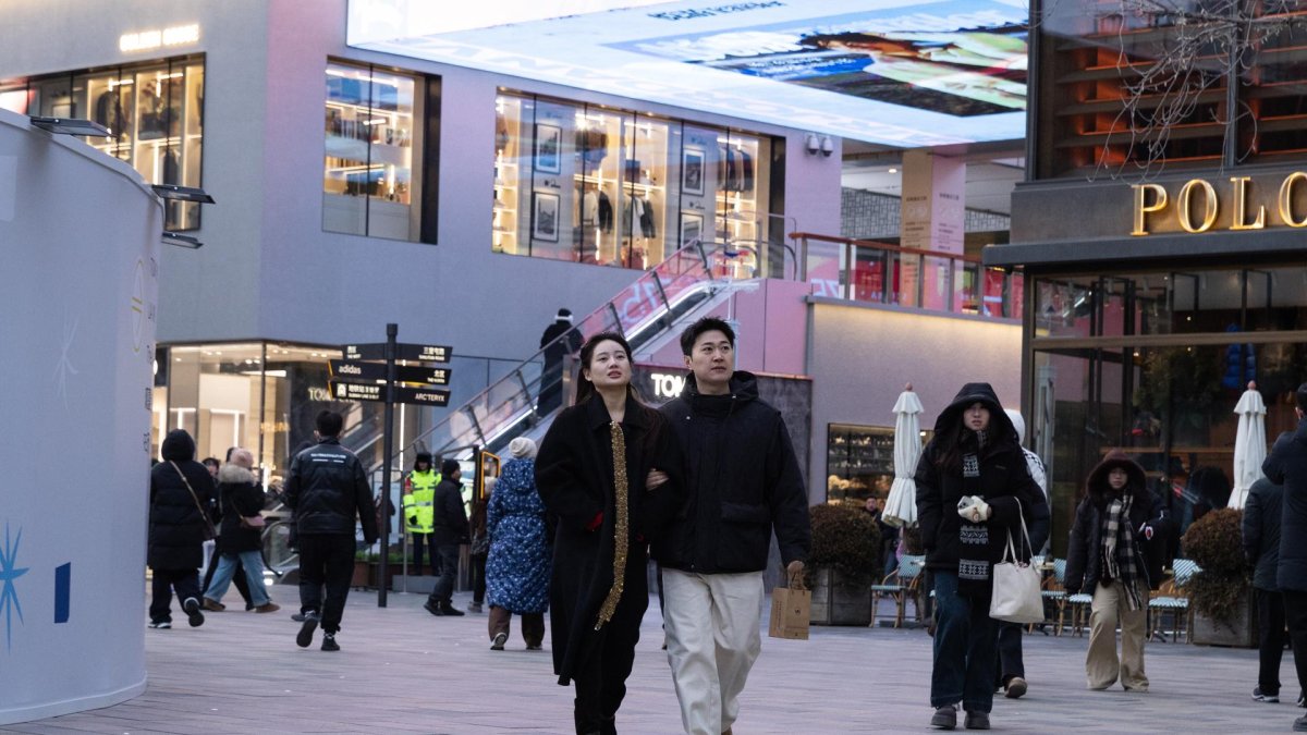 La gente camina en un centro comercial en Beijing, China, el 19 de enero de 2026.