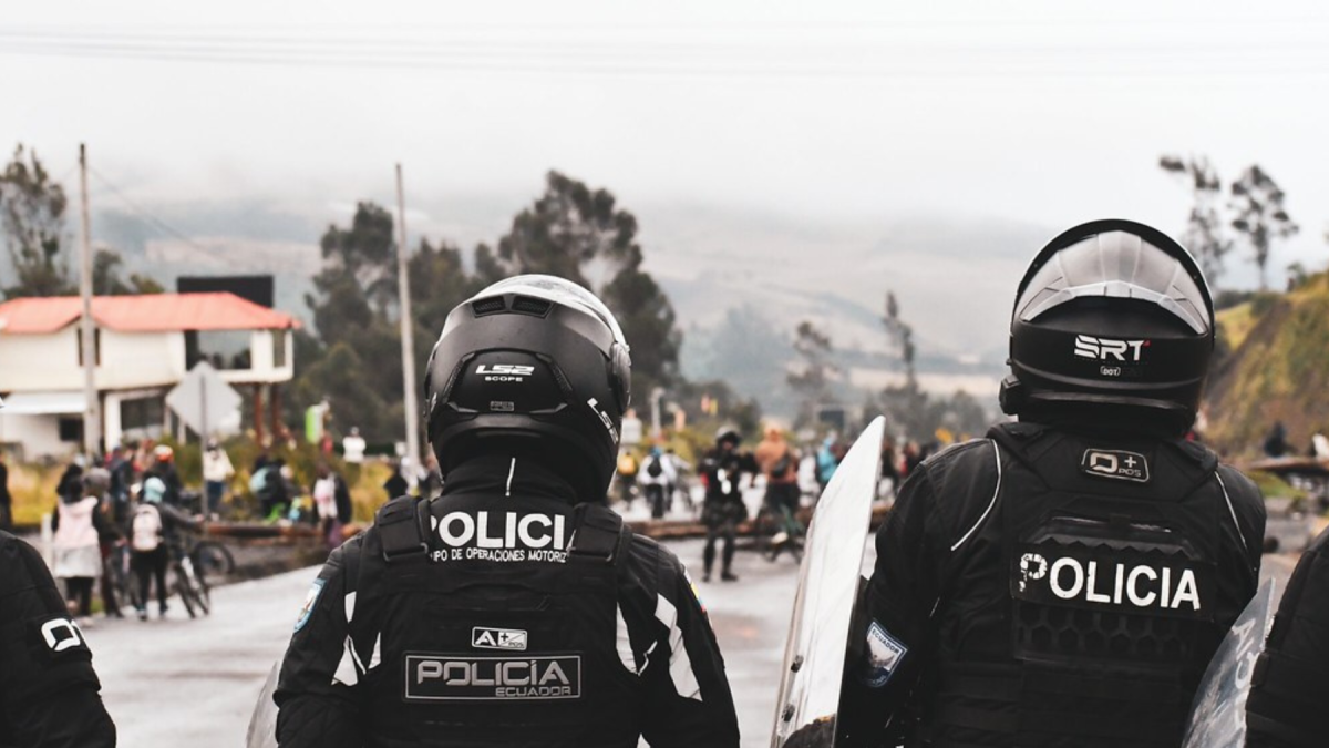 Agentes del Grupo de Operaciones Motorizadas resguardan el ingreso a una zona de alta tensión en Imbabura, durante un operativo para garantizar el libre tránsito y la seguridad ciudadana.