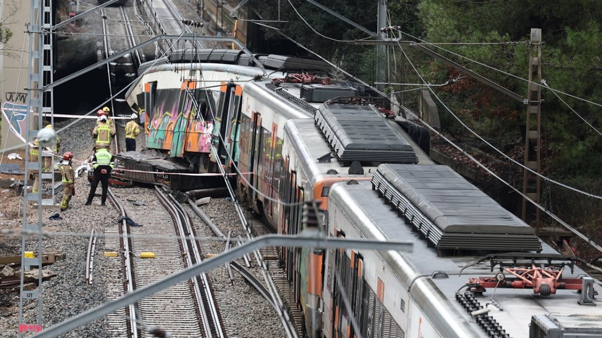 Bomberos en el lugar donde un tren de servicio regional chocó contra un muro derrumbado entre Sant Sadurni d'Anoia y Gelida, cerca de Barcelona.