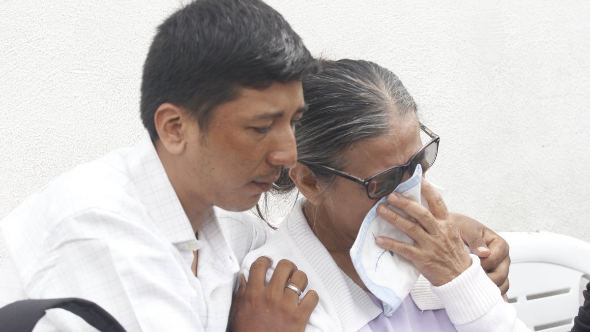 Rita Lucas recibe el consuelo de su otro hijo tras la muerte de Juan Gregorio Garcés Lucas.