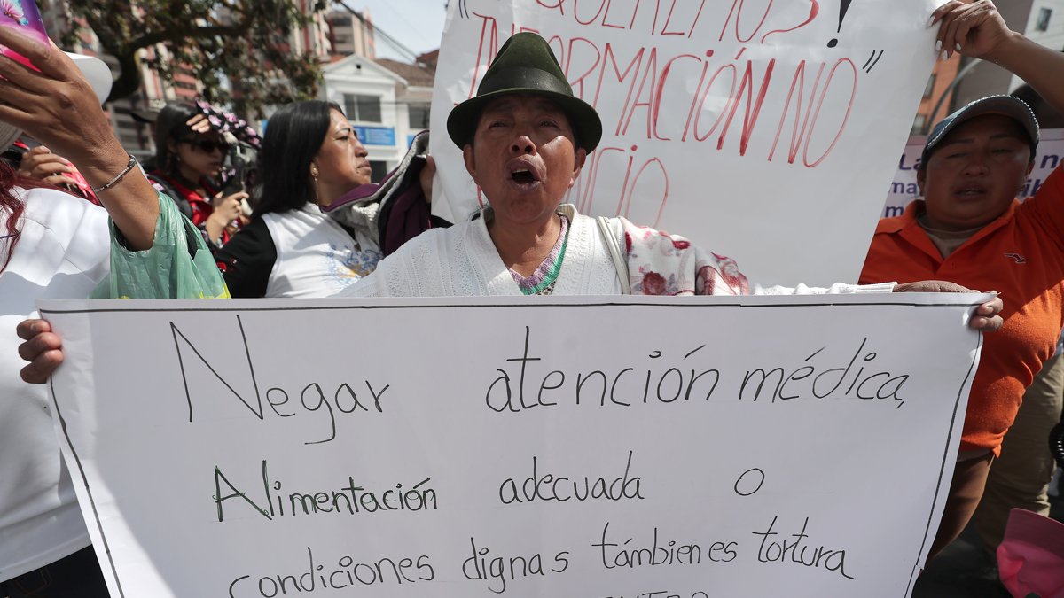 Una familiar de presos recluidos en las cárceles de Ecuador sostiene un cartel el miércoles, durante una protesta frente al Servicio Nacional de Atención Integral a Personas Adultas Privadas de la Libertad (SNAI), en Quito (Ecuador).