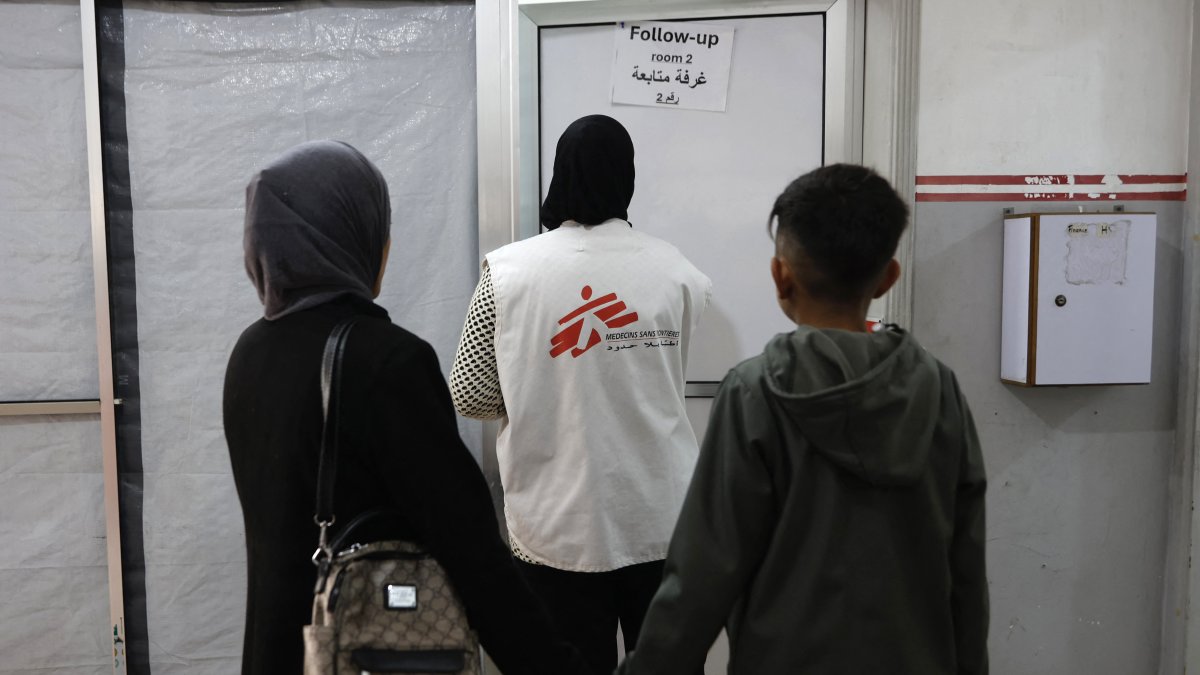 Pacientes. Pacientes siguen a un miembro del personal de Médicos Sin Fronteras (MSF) hacia la sala de seguimiento en una clínica.