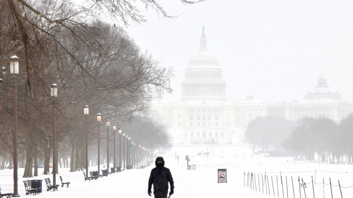 Un hombre camina por el National Mall mientras cae nieve en Washington, DC, el 25 de enero de 2026.