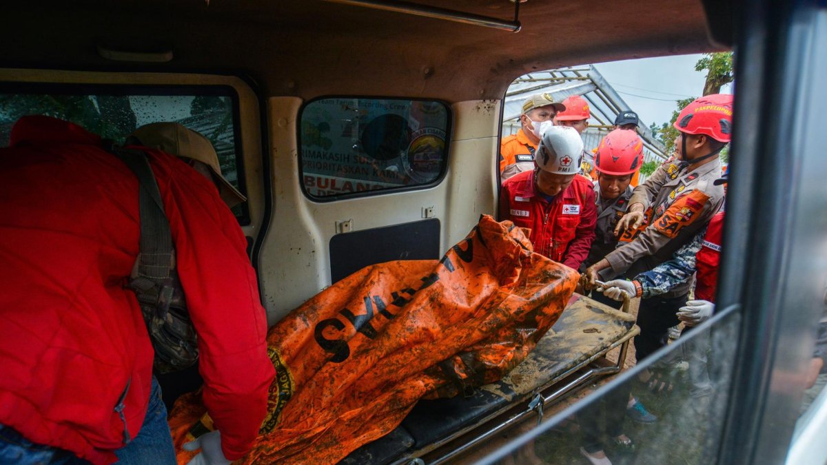 Los rescatistas llevan restos de una víctima en una zona afectada por un deslizamiento de tierra en la aldea de Pasirlangu, Indonesia, el 25 de enero de 2026.