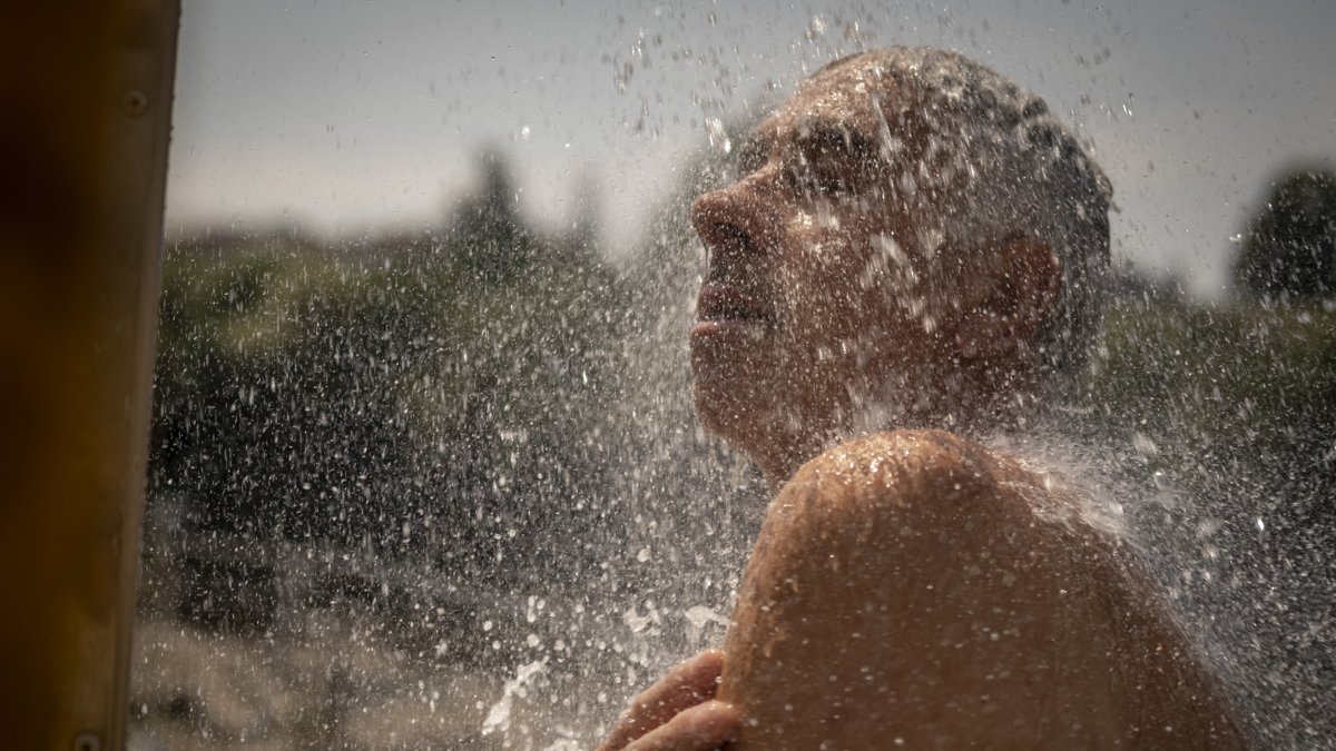 En la imagen de archivo, un hombre se refresca en una ducha en las termas de A Chavasqueira, en Ourense, España.
