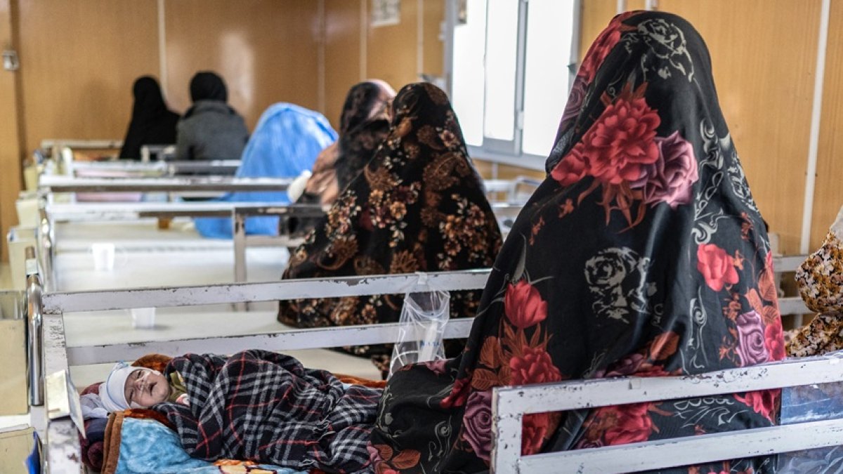 Esta fotografía, tomada el 8 de enero de 2026, muestra a mujeres afganas con sus hijos desnutridos en un hospital de Herat.