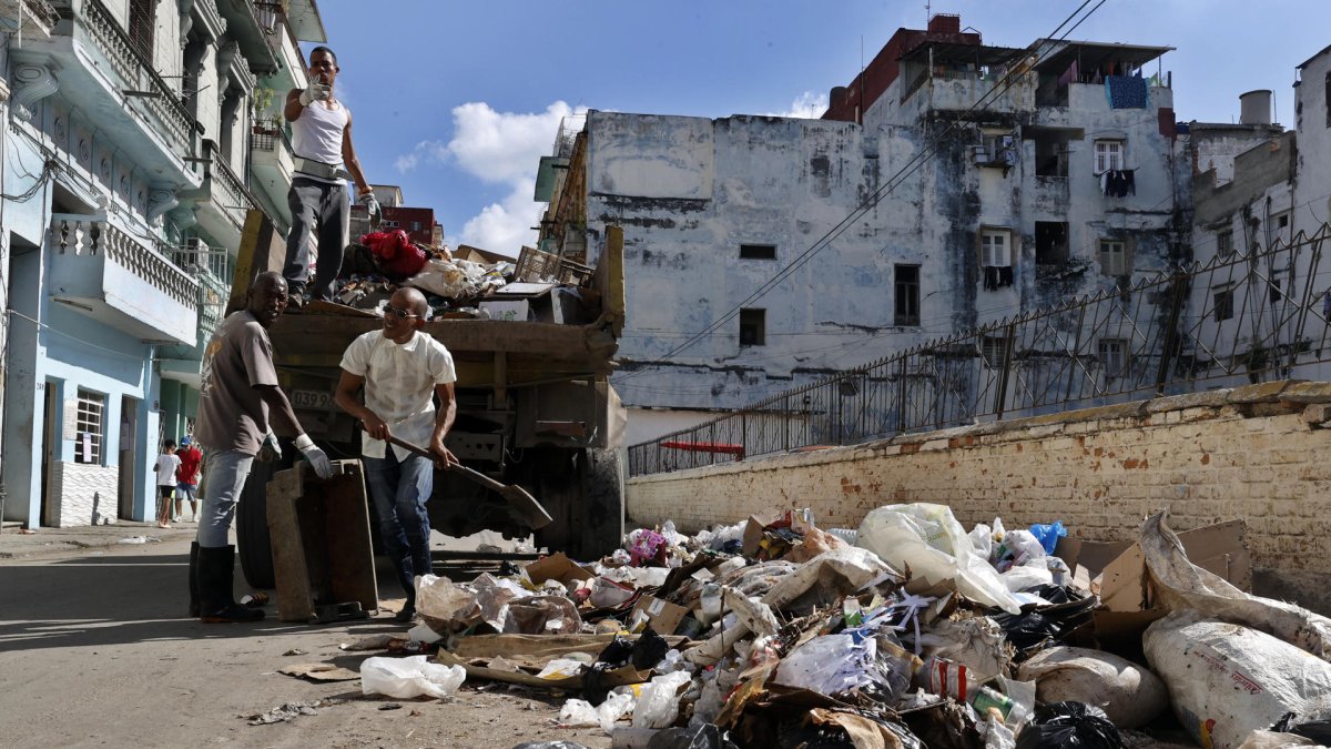 Fotografía del 22 de enero de 2026 que muestra un grupo de personas recogiendo basura en una calle, en La Habana (Cuba)