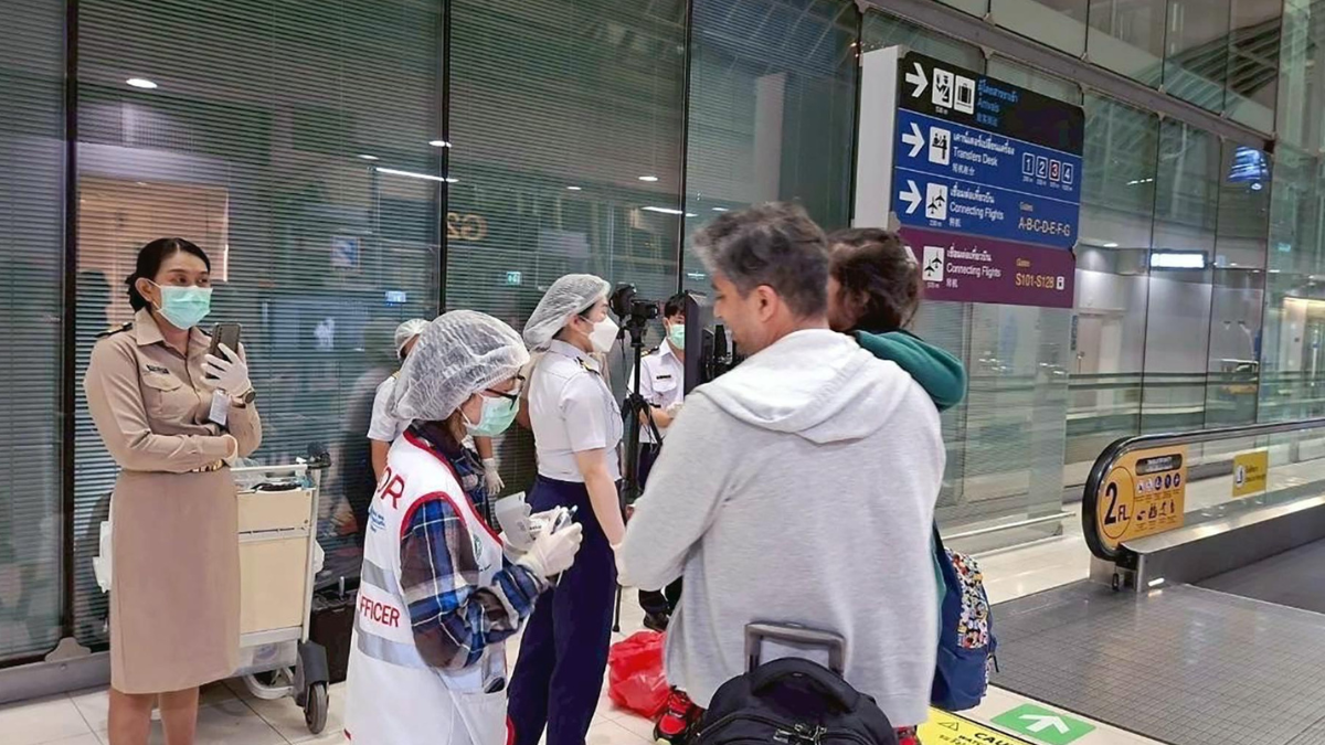 Funcionarios de salud en Tailandia controlan la temperatura de pasajeros internacionales en el aeropuerto de Suvarnabhumi, Bangkok.