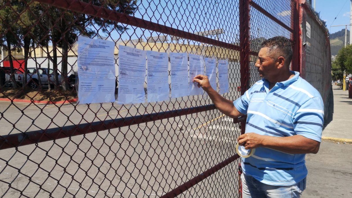 Freddy Rojas, empleado despedido de Aucas, deja notificaciones en la puerta del estadio.