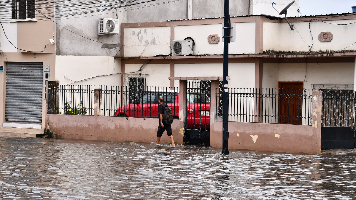 Un ciudadano camina entre calles anegadas en Machala tras las intensas lluvias que provocaron inundaciones en varios sectores