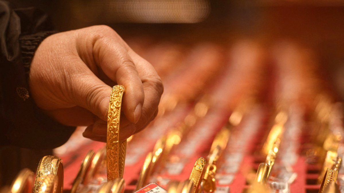 Oferta. Un cliente observa joyas de oro en una tienda de oro en Hangzhou, provincia china de Zhejiang.