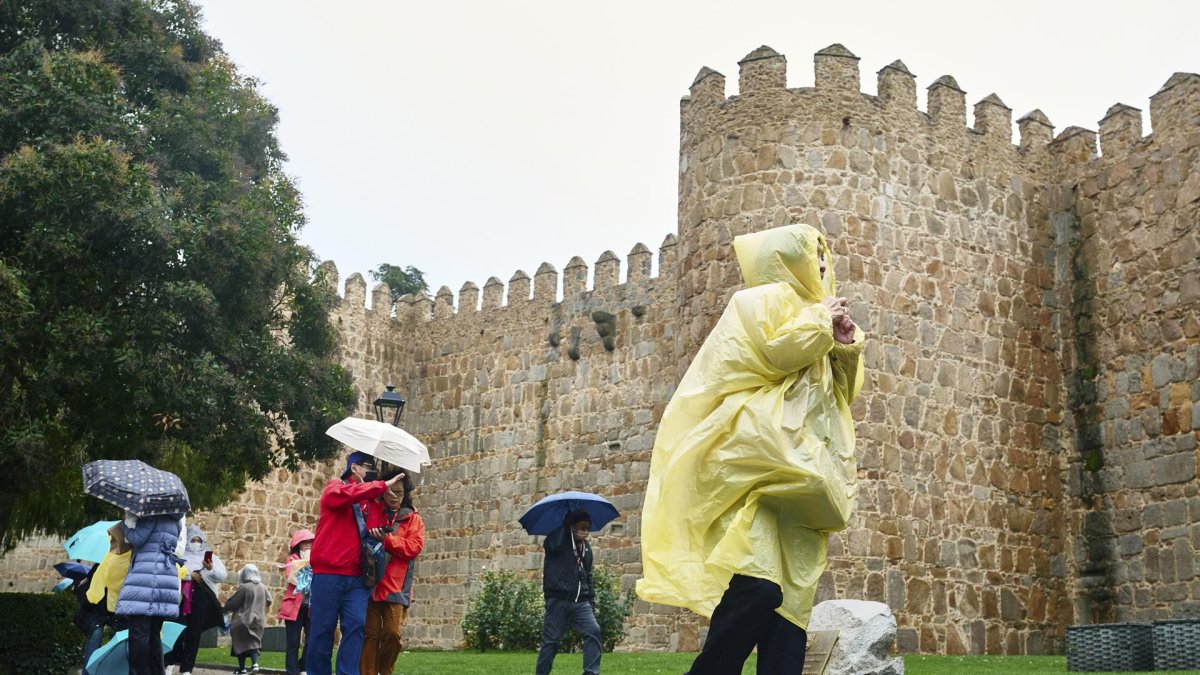 Fotografía de referencia, varias personas se protegen de la lluvia en España.