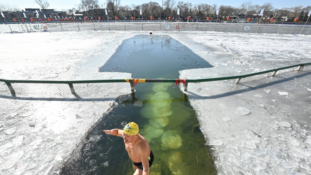 Un entusiasta de la natación invernal hace un gesto después de nadar en el lago Houhai del área escénica de Shichahai en Beijing el 20 de enero de 2026.