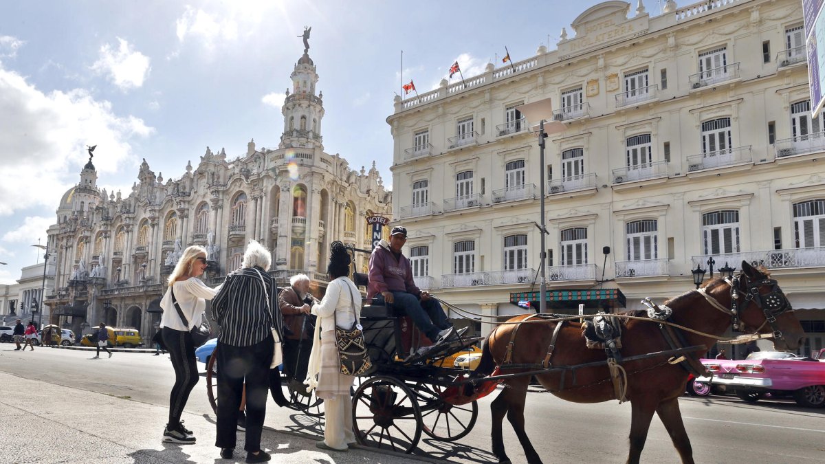 Fotografía del 29 de enero de 2026 que muestra a turistas montando en un coche alado por un caballo en La Habana (Cuba).